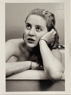 a black and white photo of a woman in a bathtub