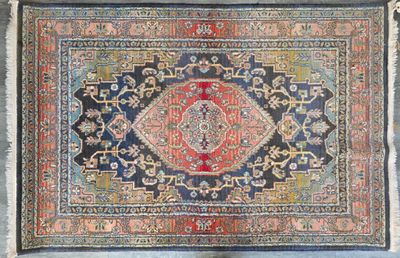 un tapis persan ancien à fond bleu et au centre rouge