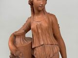 a statue of a woman holding a vase on a table