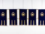 three blue and gold flags hanging from the ceiling
