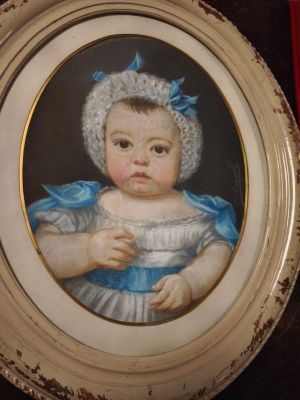 un tableau représentant un bébé vêtu d'une robe bleue et d'un bonnet