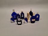 many different bottles of perfume on a white surface