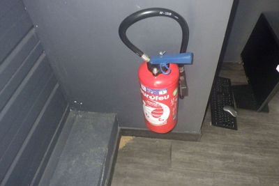 un extincteur fixé au mur d'une pièce
