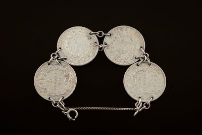 un gros plan d'un bracelet en argent orné de cinq pièces