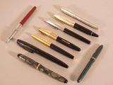 many pens that are lined up together on a table