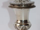 a silver vase with a bird on top of it