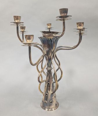 a silver candelier with five candles on it