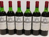 six bottles of wine are lined up in a row on a table