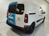 a white van with a blue stripe parked in a garage