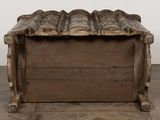 an old wooden box sitting on top of a floor next to a wall