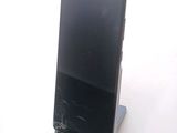 a broken cell phone sitting on a stand on a table