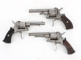 three revolvers are shown on a white surface with a white background