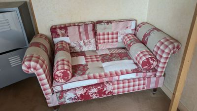 un canapé à carreaux rouges et blancs dans un coin de la pièce