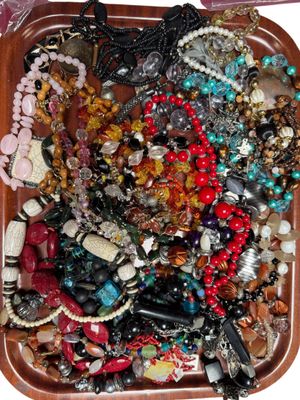 un plateau en bois rempli d'un assortiment de perles et de colliers
