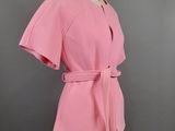 une robe rose sur un mannequin, sur fond noir