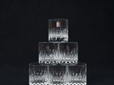 quatre verres de whisky empilés les uns sur les autres sur un fond noir