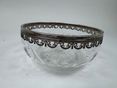 a glass bowl with a metal rim on a white surface