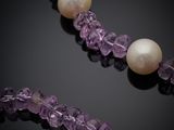 an amethorate and pearl necklace on a black surface
