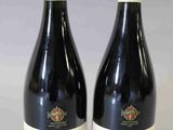 deux bouteilles de vin posées sur une table l'une à côté de l'autre