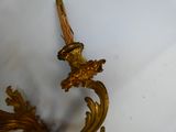 a gold colored lamp hanging on a wall next to a white wall