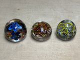 three glass marbles that are sitting on a table