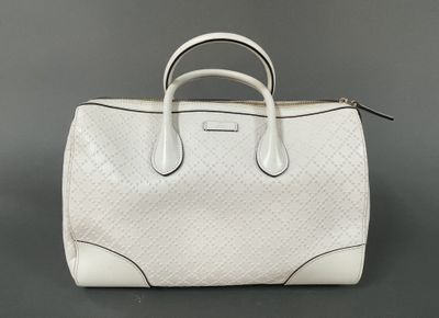 a white handbag sitting on top of a gray surface