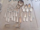 many spoons and forks laid out on the table
