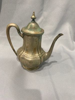 une théière en laiton ancien sur fond blanc