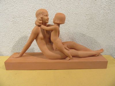 une sculpture en argile représentant une femme et un homme assis sur une table