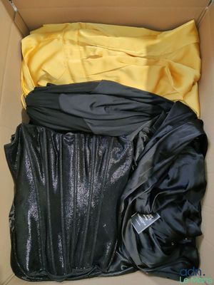 a box with a black jacket and a yellow shirt in it