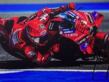 photo dédicacée d'un pilote de moto penché en avant sur un circuit