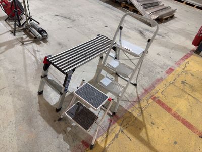 a small metal step stool next to a dolly in a warehouse