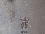 a silver plate with a cross on it on a table