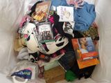 a white bag full of clothing and books on a bed