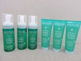 a group of four bottles of skin care sitting next to each other