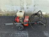 a power washer sitting on the ground next to a concrete wall