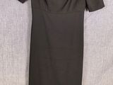 a black dress hanging on a hanger next to a black belt