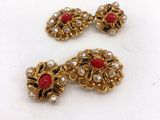 un gros plan sur une paire de boucles d'oreilles rouges et blanches