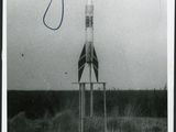 a black and white photo of a rocket sitting on top of a stand