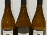 trois bouteilles de vin posées sur une table, l'une à côté de l'autre