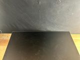 a laptop computer sitting on top of a wooden table next to a black wall