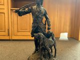 statue of a man with a dog and a gun in a room