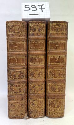 three old books are stacked on top of each other on a white surface