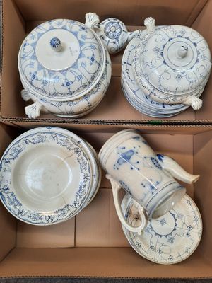 a box of blue and white china dishes and cups