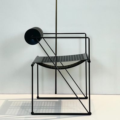 a black chair and a black lamp on a white floor