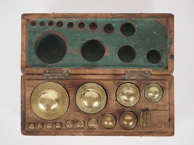 a wooden box that has a bunch of brass objects inside of it