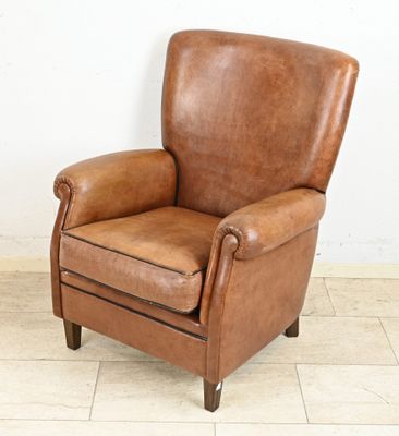an image of a brown leather chair sitting on a tiled floor