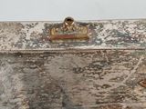 an old wooden box with a metal handle on a table