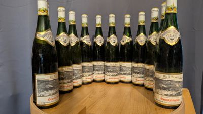 a lot of bottles of wine sitting on a wooden table