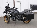 Une moto BMW garée devant un immeuble, avec une valise à l'arrière